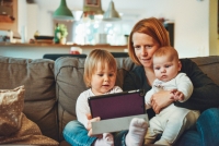 Mujer usando una tablet con sus hijos (Unsplash)